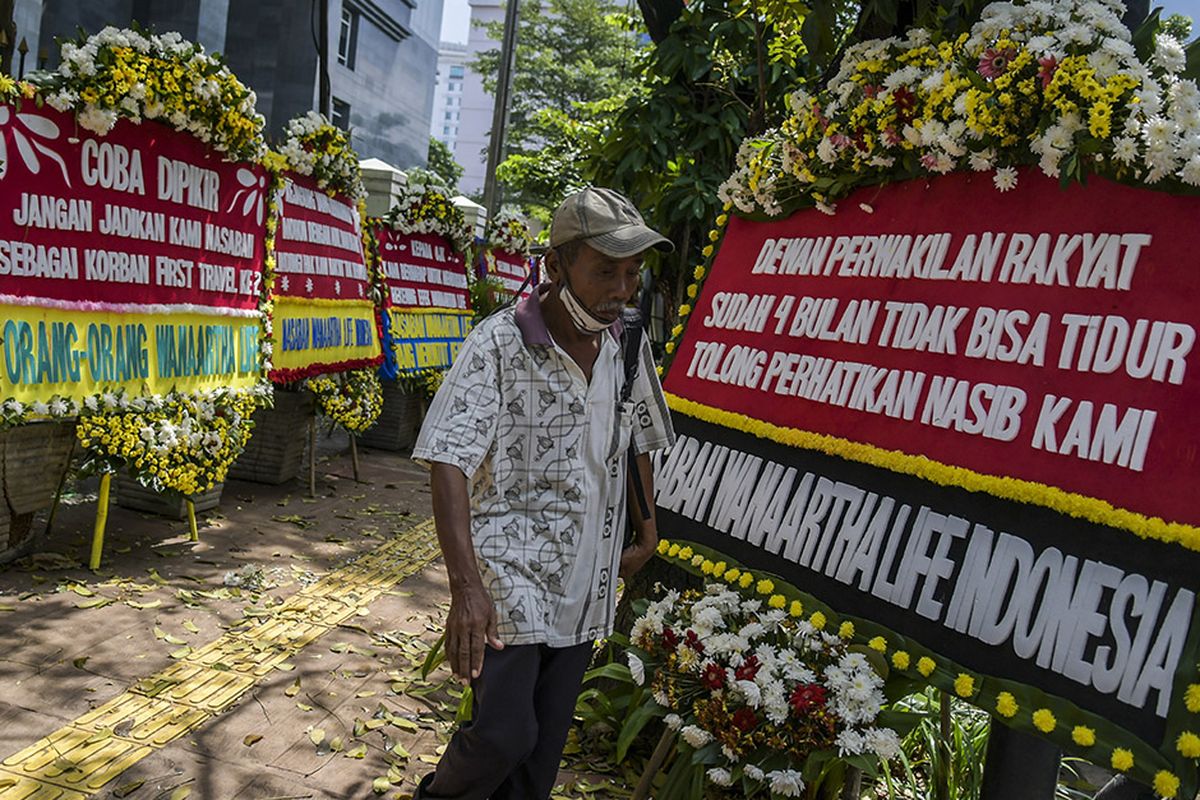 Warga melintasi karangan bunga di Pengadilan Tipikor, Jakarta, Rabu (3/6/2020). Karangan bunga tersebut berasal dari korban terdampak kasus asuransi Jiwasraya yang mengharapkan lembaga terkait untuk memberikan keadilan bagi mereka.