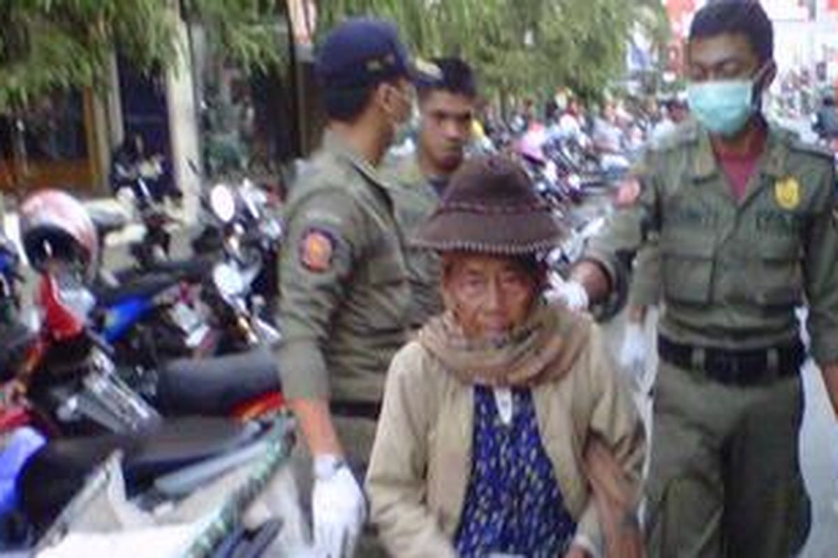 Petugas Satpol PP Pemerintah Kota Kediri, Jawa Timur saat menangkap seorang pengemis di jalan Doho, Kamis (30/8/2012) sore.