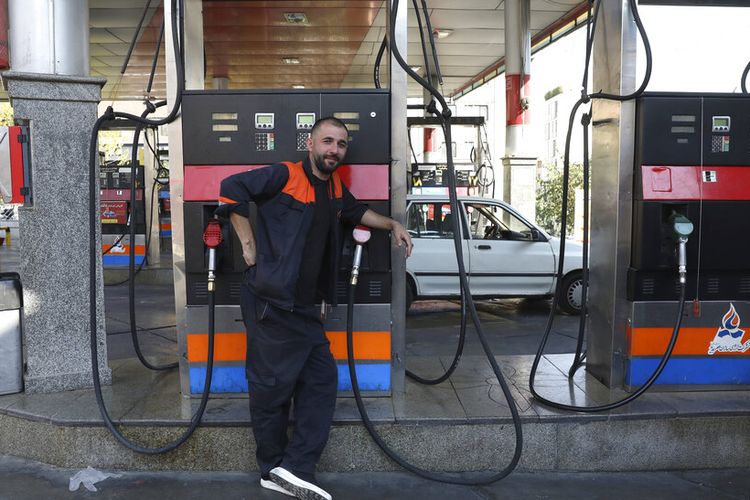 A worker leans against a gasoline pump that has been turned off, at a gas station in Tehran, Iran, Tuesday, Oct. 26, 2021. Gas stations across Iran on Tuesday suffered through a widespread outage of a system that allows consumers to buy fuel with a government-issued card, stopping sales. One semiofficial news agency referred to the incident as a cyberattack. (AP Photo/Vahid Salemi)