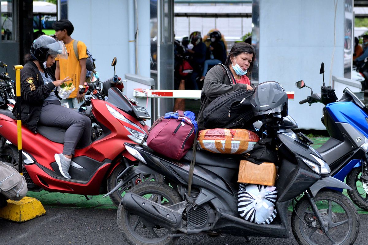 Pemudik merapikan barang bawaan yang diangkut dengan sepeda motor sebelum naik ke kapal di Pelabuhan Gilimanuk, Jembrana, Bali, Sabtu (30/4/2022). Sebanyak 33.330 unit kendaraan roda dua tercatat telah menyeberang ke Pulau Jawa melalui Pelabuhan Gilimanuk pada 22-29 April 2022 dan menjadi kendaraan yang paling banyak digunakan pemudik di Pelabuhan Gilimanuk.