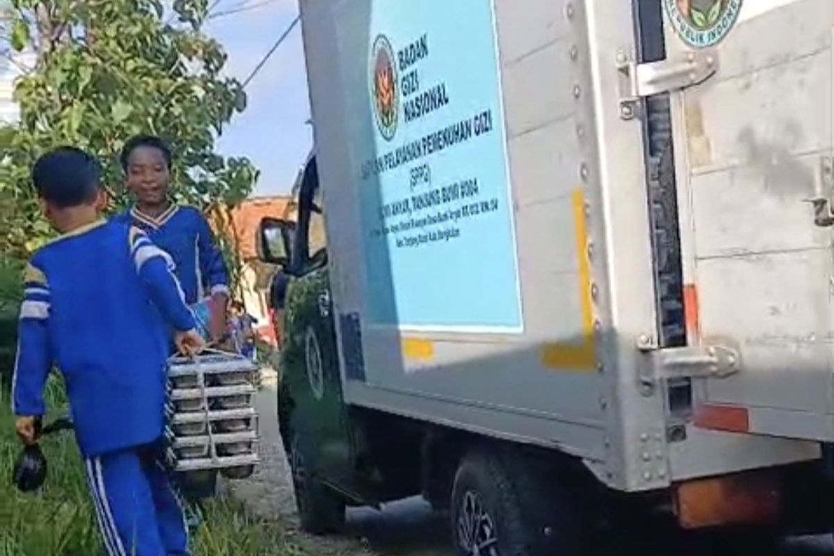 Siswa membantu petugas SPPG mengangkut MBG ke sekolah 