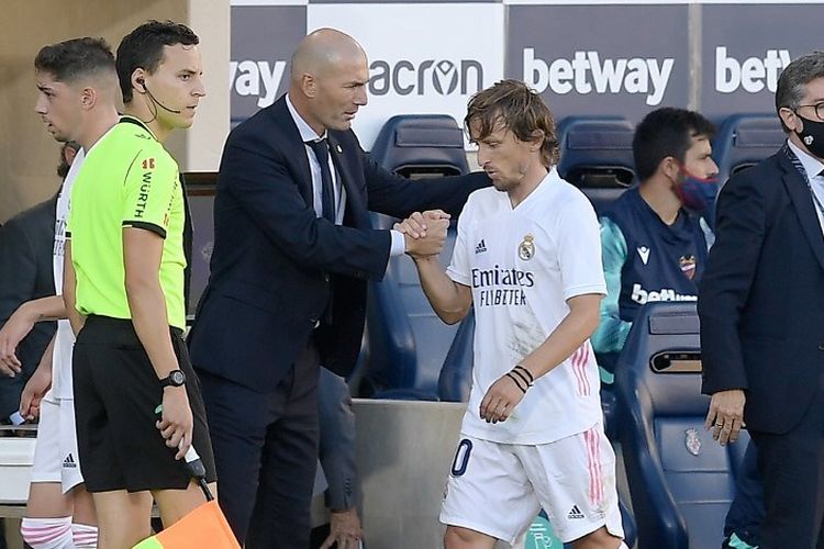 Pelatih Real Madrid Zinedine Zidane menyapa tangan gelandang Luka Modric pada laga Liga Spanyol, Levante UD vs Real Madrid, Stadion La Ceramica, 4 Oktober 2020.