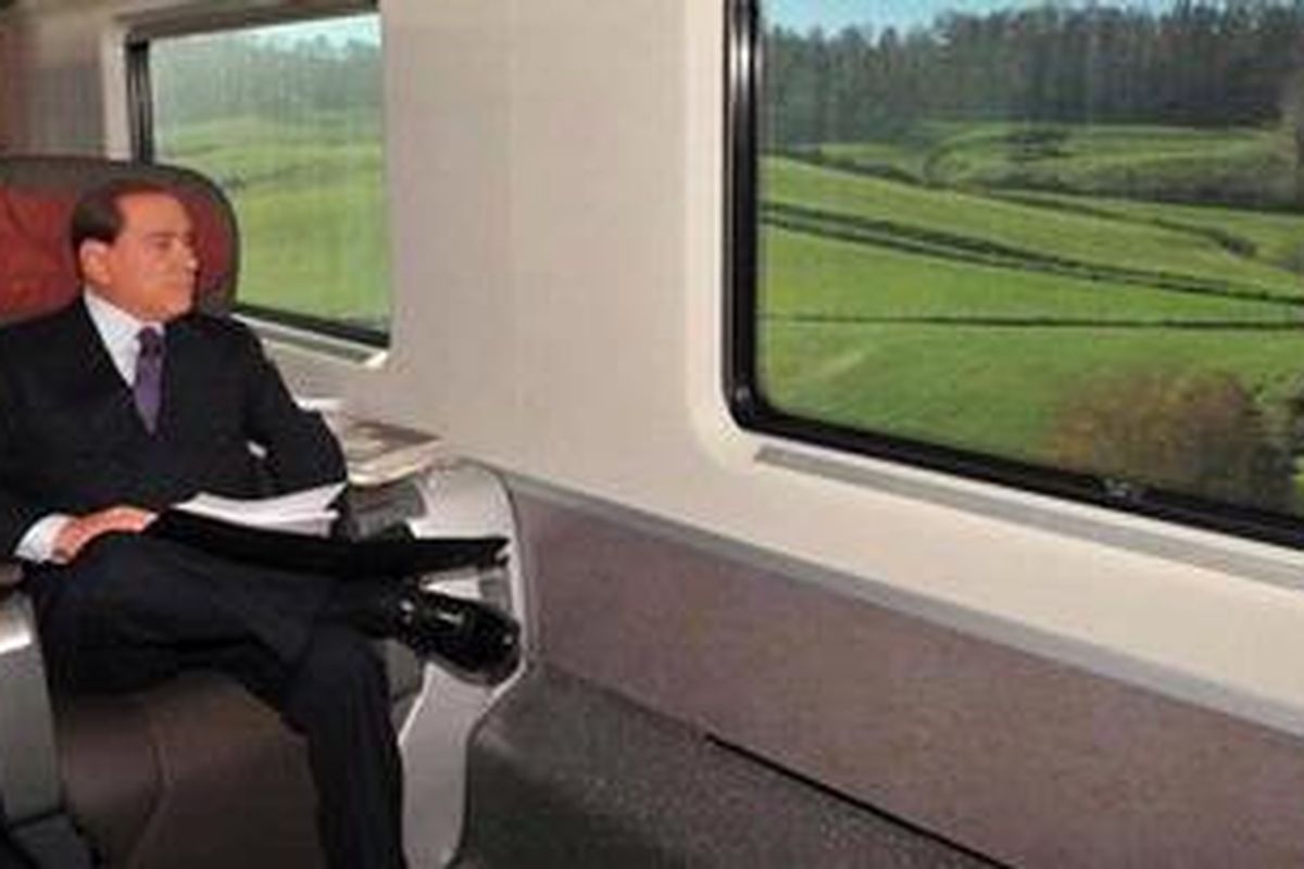 Mantan Perdana Menteri Italia sekaligus Presiden AC Milan, Silvio Berlusconi, menikmati perjalanan kereta api dari Roma ke Milan, Kamis (29/12/2012). Ia sempat dikabarkan akan menjual klubnya karena kesulitan ekonomi.