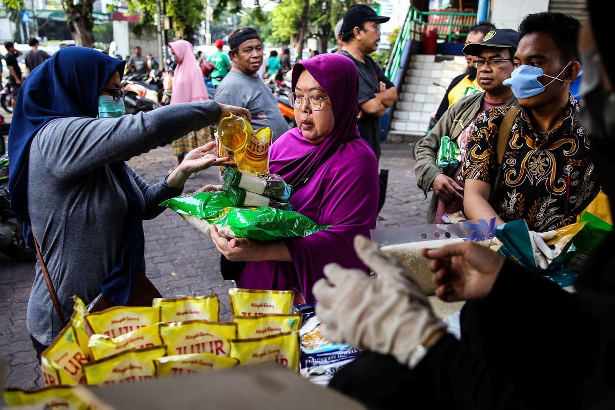 Warga membeli bahan pokok berupa minyak dan beras saat operasi pasar stok pangan di Pasar Rawamangun, Jakarta Timur, Kamis (19/3/2020). Perum Bulog bekerja sama dengan Sugar Group Companies menggelar kegiatan operasi pasar pangan dalam rangka menjamin ketersediaan bahan pangan pokok, serta menjaga stabilitas harga ditengah kekhawatiran masyarakat akibat pandemi virus Corona atau Covid-19. Operasi pasar stok pangan akan berlangsung selama seminggu di beberapa pasar untuk wilayah DKI Jakarta dan Banten.