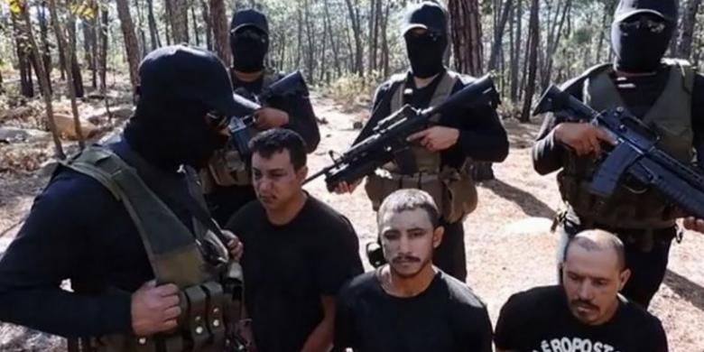 Gambar yang diambil dari Youtube ini diunggah pada tahun 2015 oleh kartel obat bius Jalisco New Generation (JNG), Meskiko, memperlihatkan anggota pasukan bersenjata mereka mengenakan masker dengan sandera dari geng narkoba saingannya di Michoacan, Meksiko.