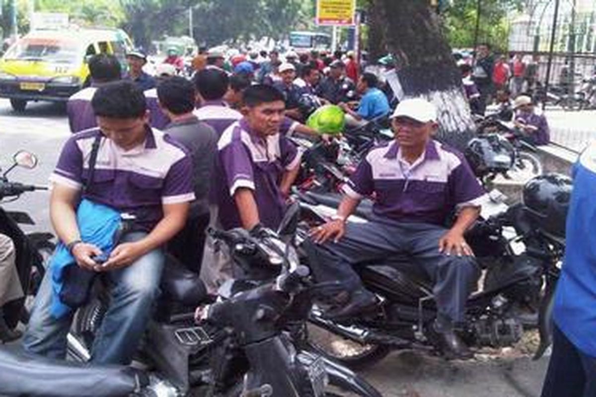 Pekerja rekanaan PLN Sumut beristirahat saat unjuk rasa di Kantor PLN Sumut.