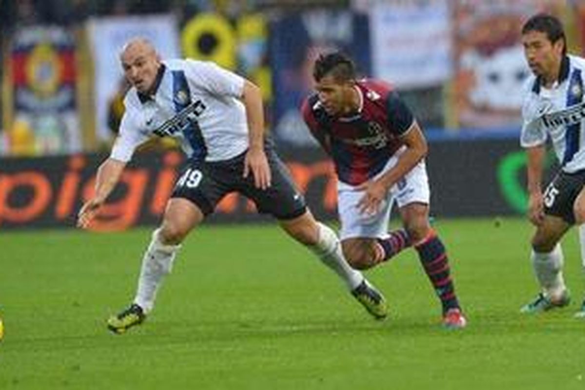 Gelandang Inter Milan dari Argentina, Esteban Matias Cambiasso (kiri), berebut bola melawan gelandang Bologna asal Perancis, Saphir Sliti Taider (tengah), sementara disaksikan bek Inter Milan dari Jepang, Yuto Nagatomo, dalam laga Serie-A di Renato DallAra, Minggu (28/10/2012). Inter akhirnya menang 2-0. 