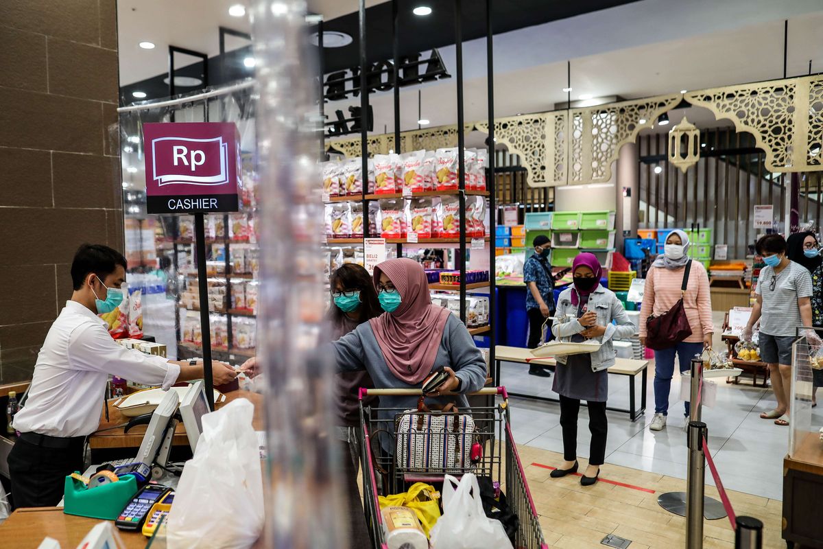 Pembeli menggunakan masker saat antre dengan menjaga jarak untuk melakukan pembayaran dari balik plastik pembatas di supermarket AEON Mal Serpong, Tangerang, Banten, Selasa (26/5/2020). Pemerintah Indonesia bersiap menerapkan tatanan baru (new normal) dalam waktu dekat. Salah satunya dengan mulai membuka pusat perbelanjaan secara bertahap di bulan Juni mendatang.