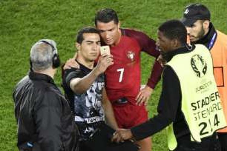 Cristiano Ronaldo melayani permintaan foto dari penggemar usai laga antara Portugal dan Austria di Parc des Princes, Paris, pada Sabtu (18/6/2016) waktu setempat.
