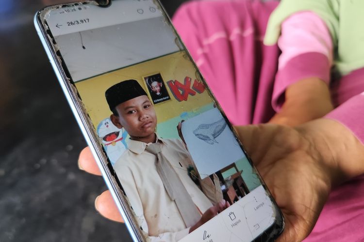 Sumilah (45) menunjukkan foto anaknya, Alif Riski Hanip Widodo (14) yang meninggal dunia setelah diduga dipukuli oleh pelatih silatnya, saat ditemui di rumah duka pada Rabu (25/9/2024).