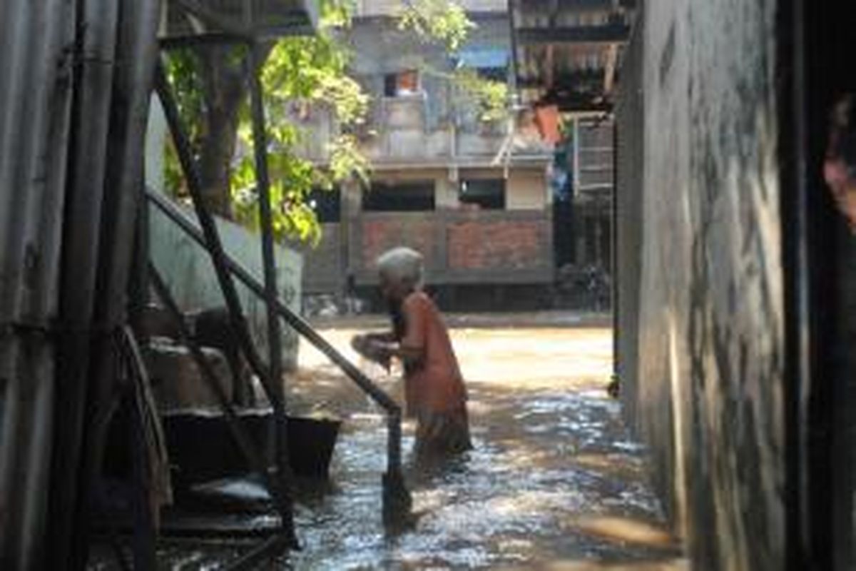 Seorang warga Kampung Pulo, Kampung Melayu, Jatinegara, Jakarta Timur, membersihkan rumah yang kotor akibat luapan air Kali Ciliwung, Selasa (23/7/2013).