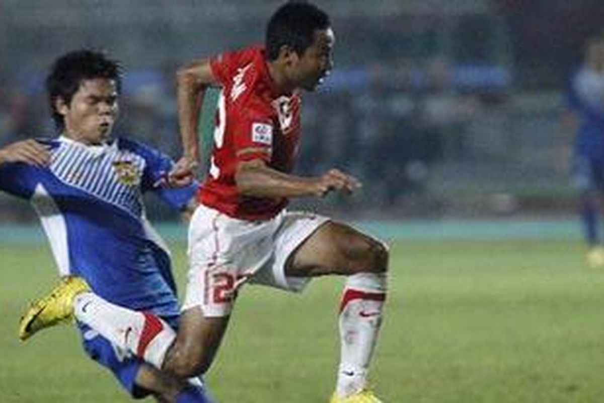 Pemain Indonesia, Muhammad Ridwan (kanan), terlepas dari penjagaan pemain Laos, Ketsada Souksavanh, dalam Piala Suzuki AFF 2010 di Stadion Utama Gelora Bung Karno, Sabtu (4/12/2010). Indonesia menang 6-0.