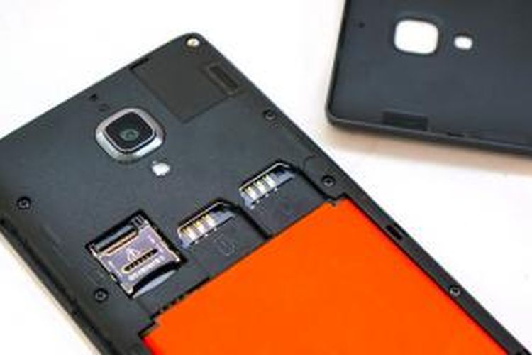 Kompartemen baterai Redmi 1S dengan baterai berwarna oranye, dua slot SIM card, dan slot micro-SD