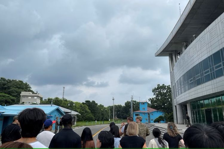 Travis King (mengenakan pakaian hitam dan topi hitam) tampak dalam gambar mengikuti tur di zona demiliterisasi di Panmunjom.