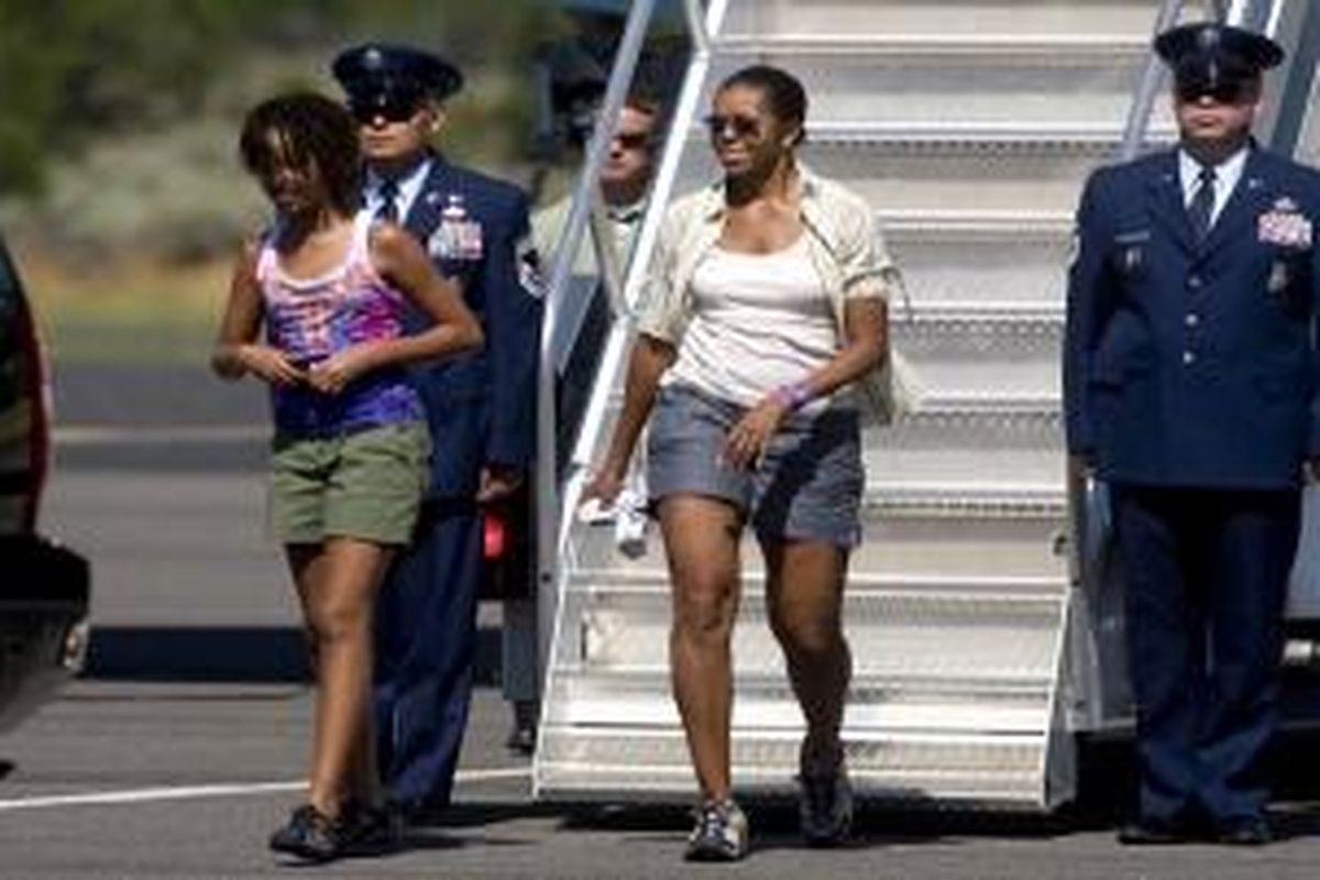 Michelle Obama bercelana pendek saat turun dari pesawat Air Force One. 