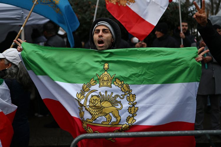 Pedemo anti-rezim Iran membawa bendera lama Iran sebelum Revolusi 1979, bergambar Singa dan Matahari, ketika berunjuk rasa di luar Kedutaan Besar Iran di London, Inggris, 9 Januari 2026.