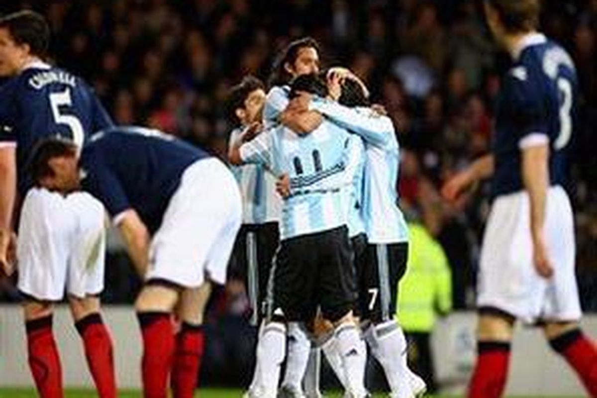 Maxi Rodriguez disambut rekan-rekannya setelah mencetak gol ke gawang Skotlandia.