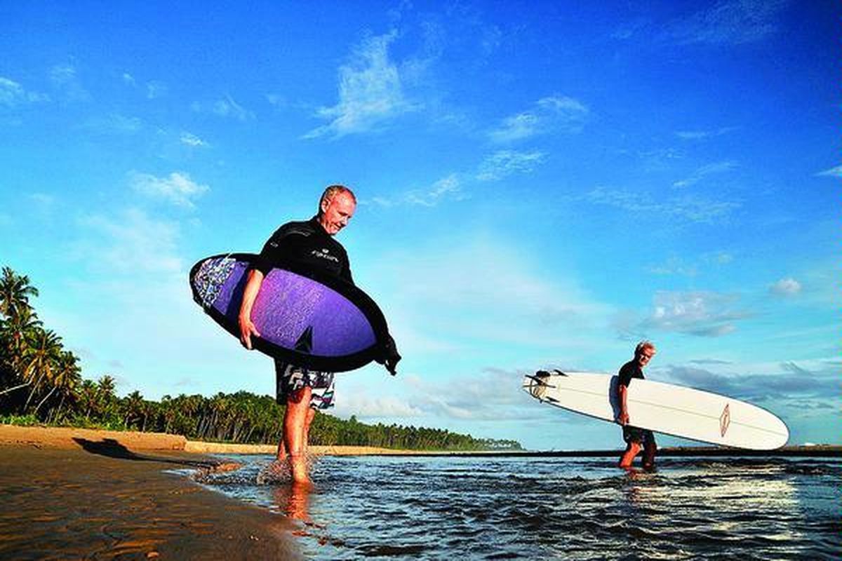 Wisatawan dari Kanada hendak berselancar di pantai barat, Kecamatan Teupah Barat, Kabupaten Simeulue, Aceh, Jumat (13/4). Selain berselancar, wisatawan ini juga  dapat menikmati  laut lepas Simeulue dengan menyelam.