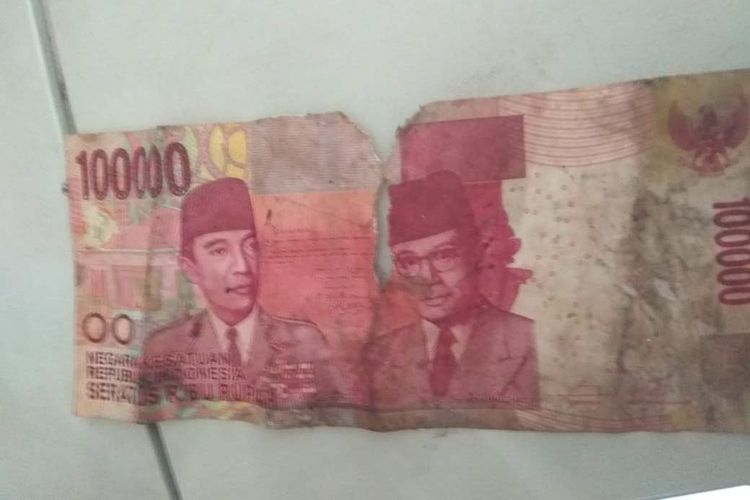 Kondisi uang kertas pecahan Rp 100.000 yang robek dan kotor.