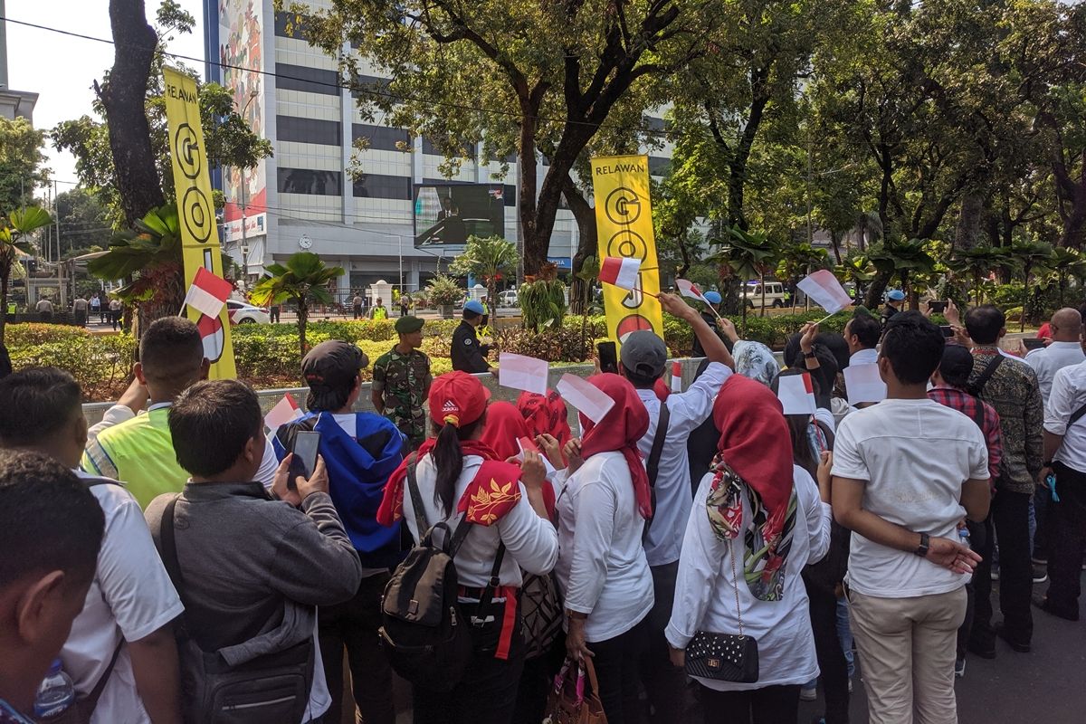 Warga menyanyikan lagu Indonesia Raya saat Presiden Jokowi melintasi Jalan Merdeka Barat, Gambir, Jakarta Pusat, menuju Gedung DPR RI, Minggu (20/10/2019).