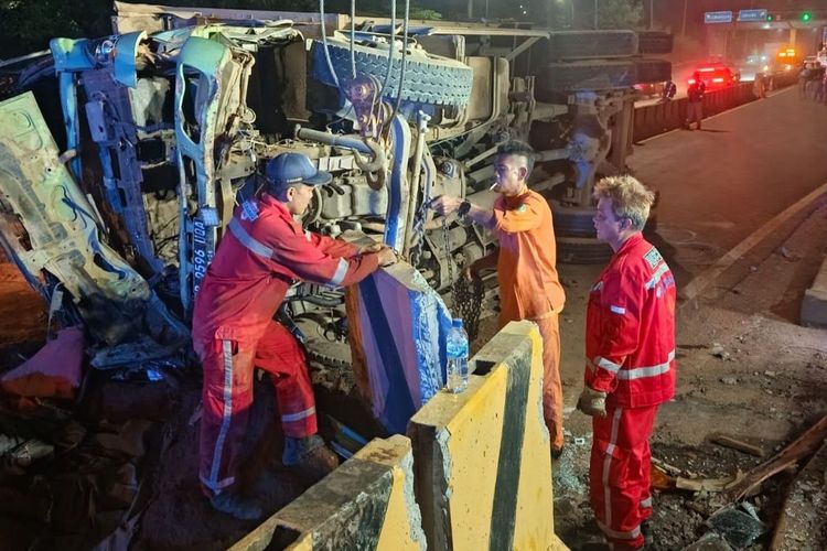 Evakuasi dump truck bermuatan tanah yang terguling di ruas GT Karawang Barat, Karawang, Jawa Barat, Rabu (30/7/2025).
