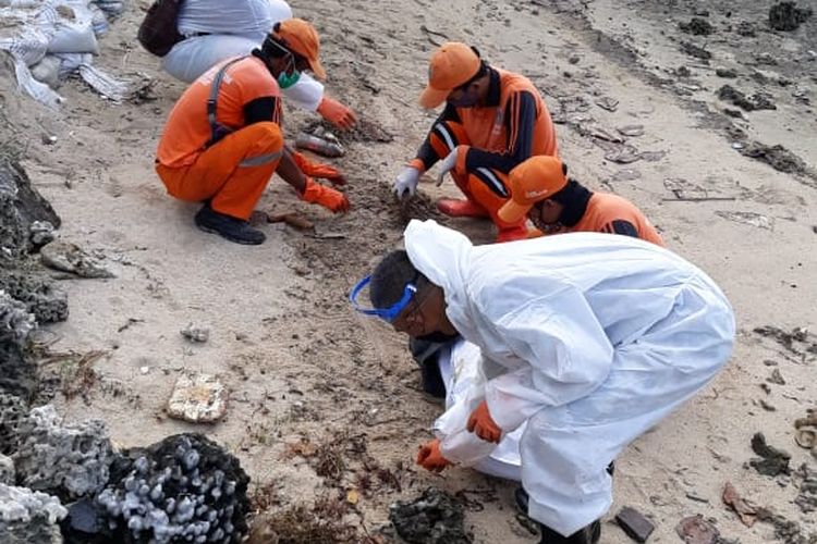 Petugas PPSU Kep Seribu dibantu oleh pihak Pertamina mengumpulkan gumpalan minyak di pinggir pantai Pulau Pari, Kep. Seribu, Rabu (12/8/2020)
