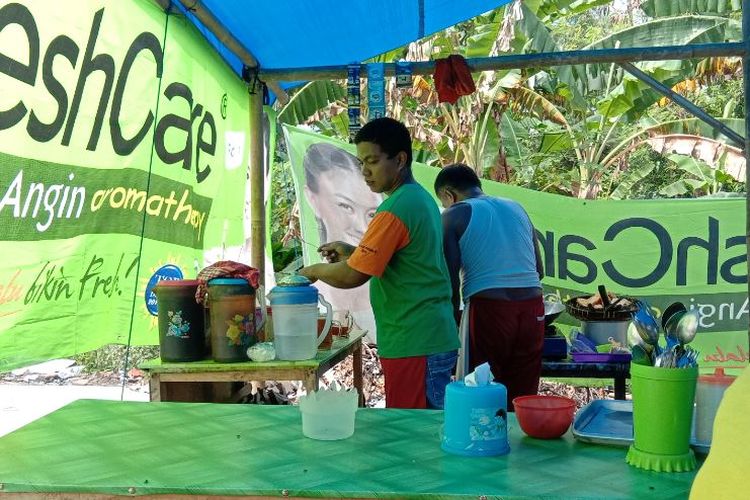 Galih dan satu rekannya menyiapkan minuman dan menggoreng aneka lauk.