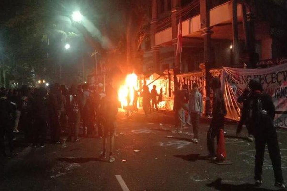 Massa Arek-Arek Malang Turun Ke Jalan saat menggelar aksi demo tolak UU TNI depan Gedung DPRD Kota Malang, Minggu (23/3/2025). Hingga memasuki malam hari, aksi massa makin ricuh. 