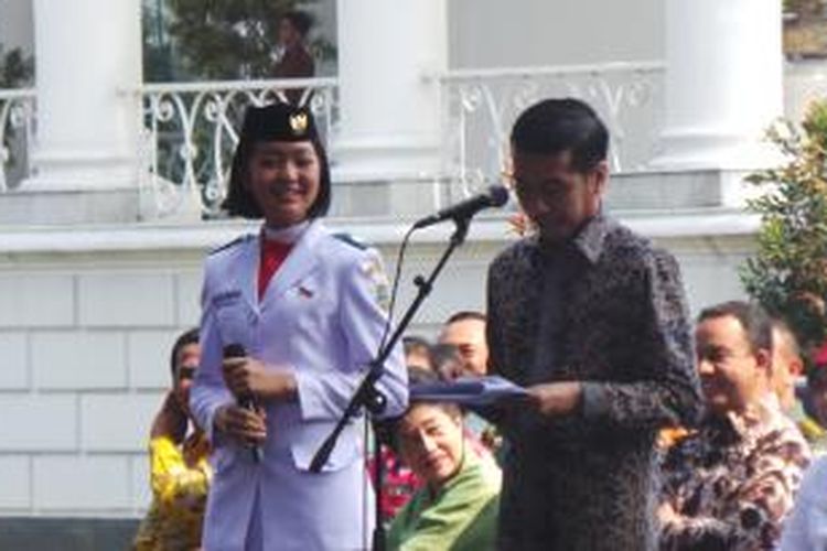 Presiden Joko Widodo bersama anggota Pasukan Pengibar Bendera Pusaka (Paskibraka), Maria Felicia Gunawan di Istana Bogor.