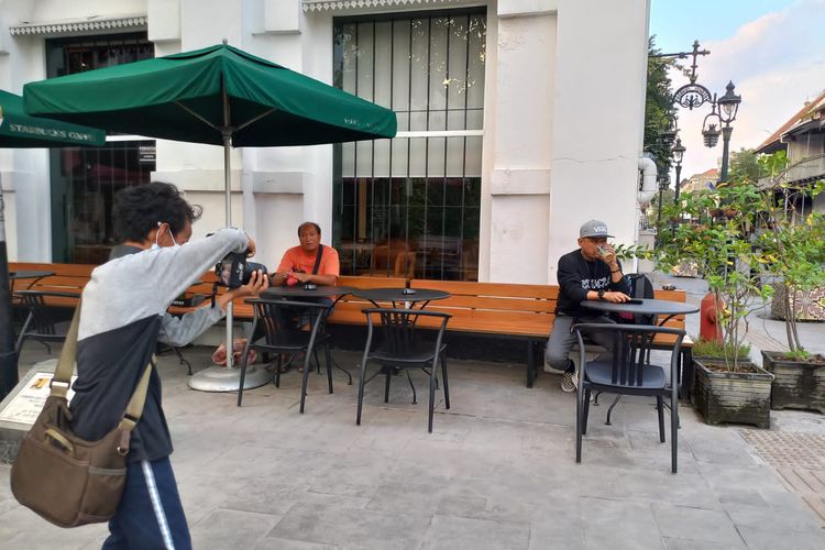 Kaka sedang mengarahkan wisatawan untuk mendapat posisi foto yang bagus di Kota Lama Semarang.