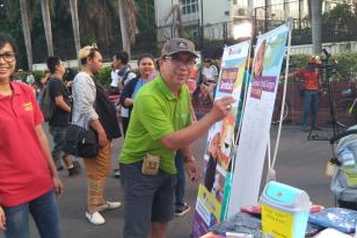 Salah seorang warga memberi tanda tangan sebagi bentuk dukungan untuk Rafi, anak yang lahi dengan kelainan organ kelamin, di car free day, Minggu (13/12/2015). 