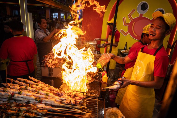 Pramusaji melakukan atraksi saat membuat makanan di area Jakarta Fair 2024 di JIExpo Kemayoran, Jakarta, Rabu (12/6/2024). Pameran terbesar se-Asia Tenggara tersebut diikuti sebanyak 2.550 peserta yang berasal dari berbagai skala usaha baik perusahaan multinasional, usaha besar, menengah dan kecil, BUMN, anjungan pemerintah provinsi dan kabupaten dari berbagai penjuru tanah air yang berlangsung hingga 14 Juli 2024 . ANTARA FOTO/Bayu Pratama S/aww.