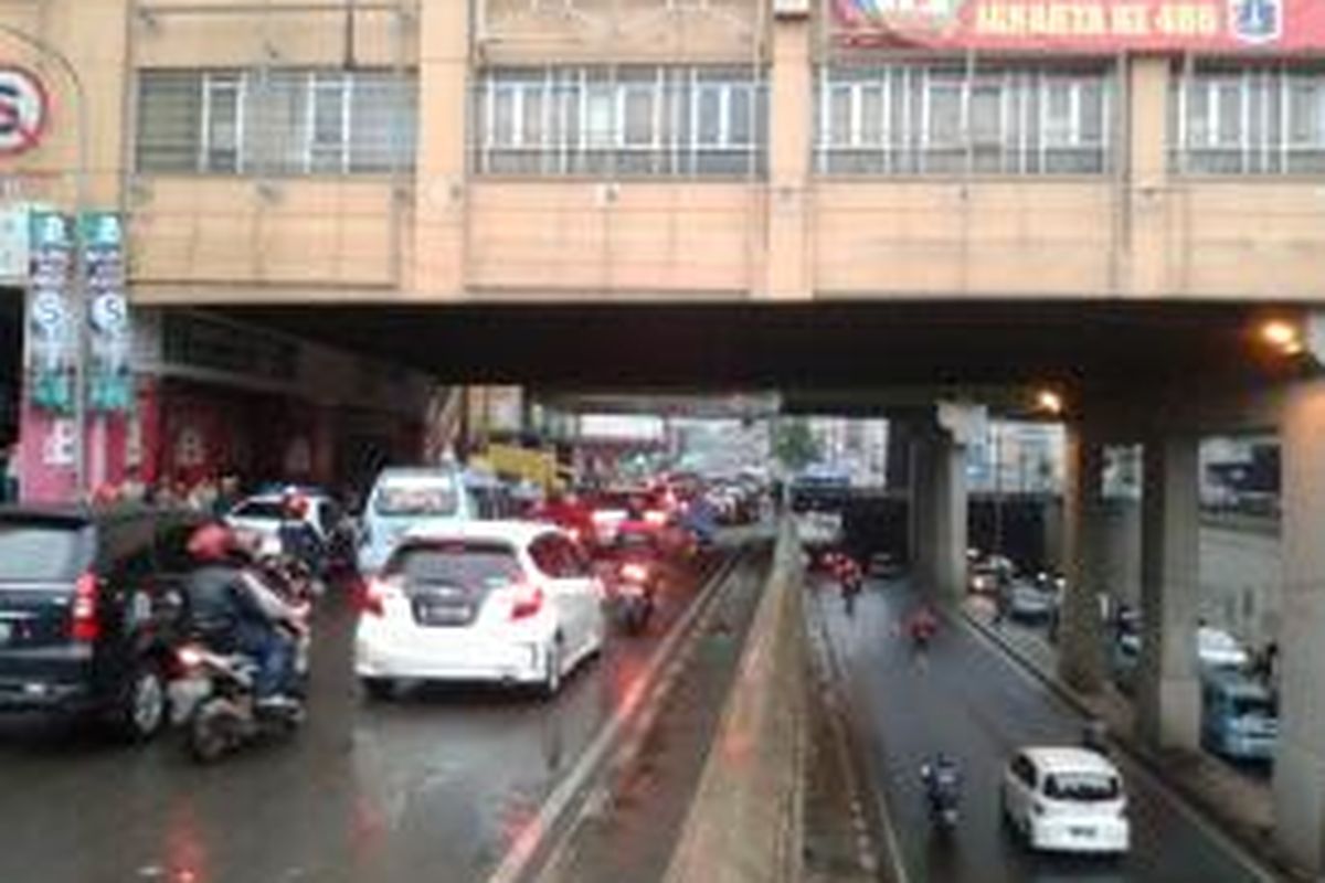 Lalu lintas di bawah jembatan penghubung Pasar Tanah Abang, Jakarta Pusat, yang lebih tertib, Senin (22/7/2013). Mulai hari ini, kendaraan yang dari arah Pejompongan (selatan) hendak menuju Cideng (utara) maupun sebaliknya, wajib melewati terowongan Tanah Abang. Adapun jalur jalan KH Mas Mansyur hanya diperuntukan bagi kendaraan yang hendak berbelanja dengan belok kiri ke arah Jalan Kebon Jati, ataupun  kendaraan yang hendak putar balik ke arah kanan menuju kawasan Bundaran HI