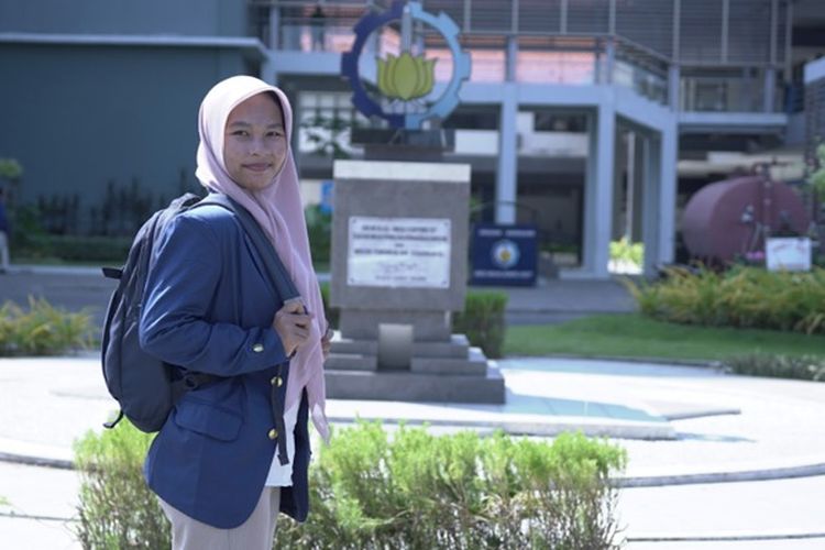 Linggas, remaja putri penerima manfaat program Beasiswa YES dari Dompet Dhuafa, sedang berfoto di depan gedung Institut  Teknologi Sepuluh Nopember (ITS), Surabaya. Linggas berkat Beasiswa YES berhasil diterima kuliah di ITS. 