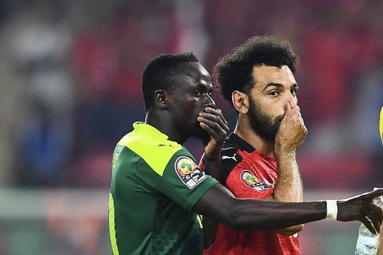 Dua rekan setim Liverpool, Sadio Mane dan Mohamed Salah, berbincang jelang babak adu penalti pada laga Senegal vs Mesir di final Piala Afrika 2021, Senin (7/2/2022) dini hari WIB. Terkini, Sadio Mane sudah dipastikan tidak akan bermain di Piala Dunia 2022 karena cedera.