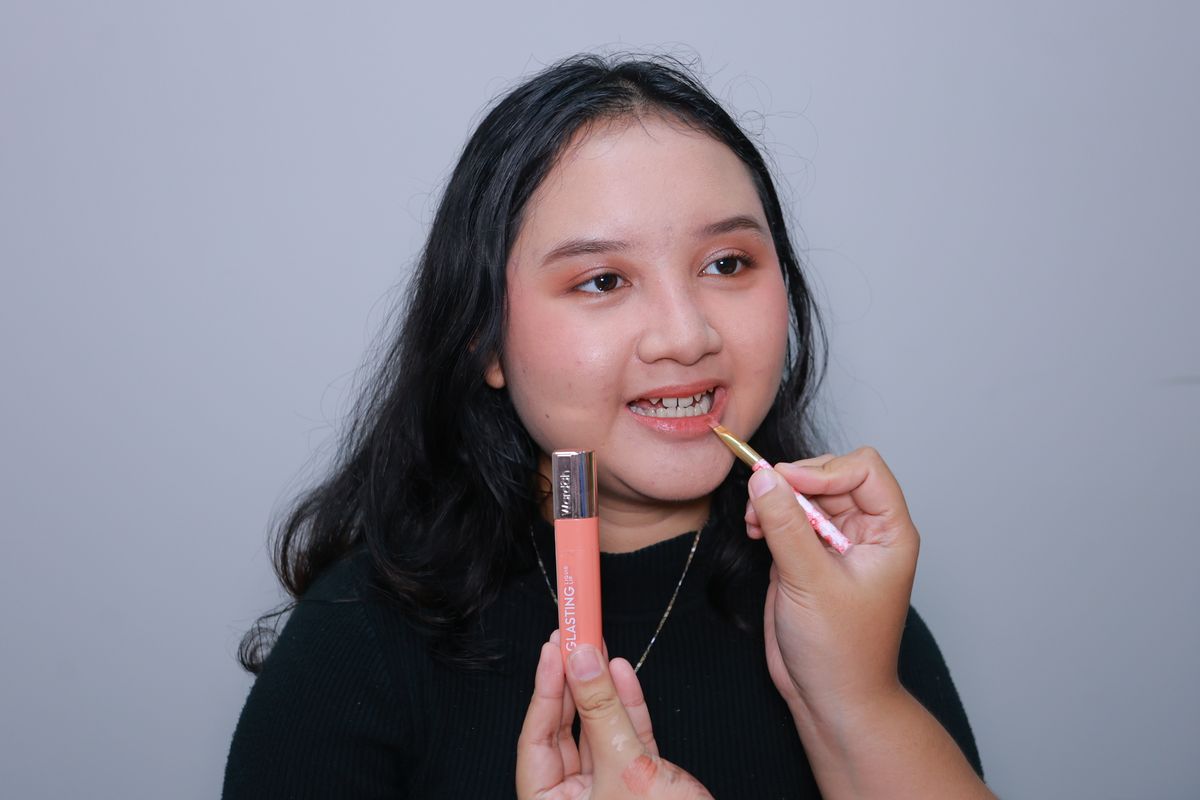 Mengaplikasikan lipstik.
