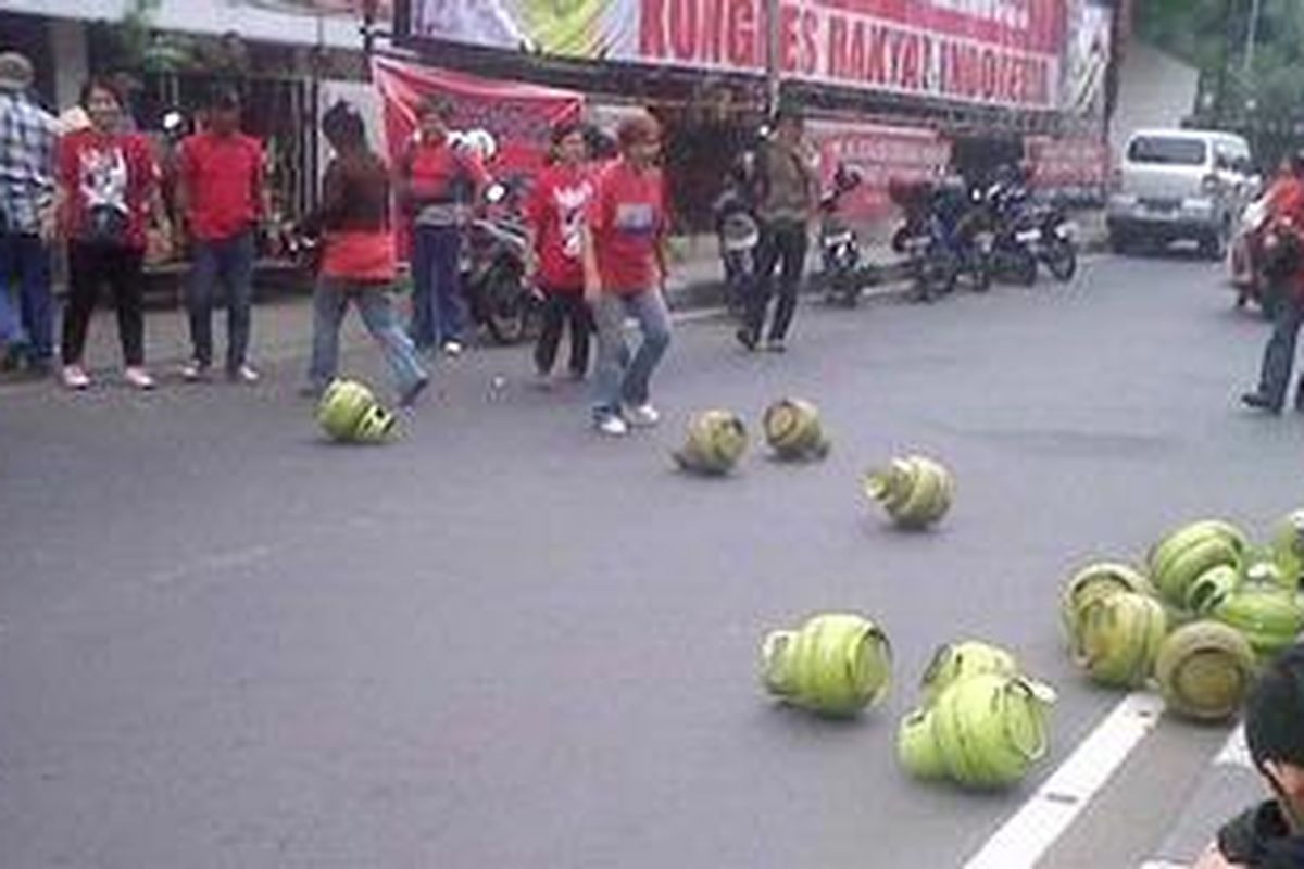 DILEMPAR - Tabung-tabung elpiji dilemparkan ke jalan di Jakarta, Minggu (18/7/2010). Dimotori LSM Bendera, puluhan warga memprotes kualitas tabung gas karena kerap meledak.