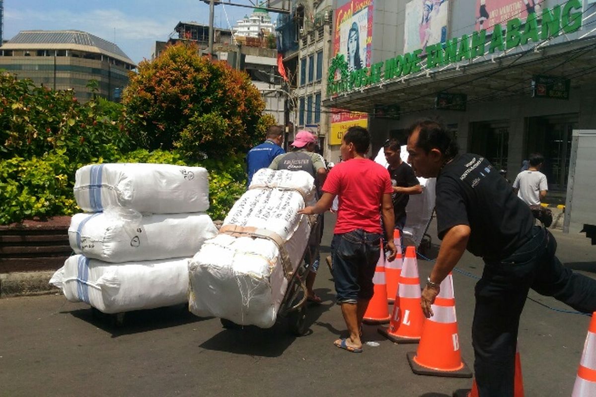 Porter di Pasar Tanah Abang masih nekat menerobos traffic cone yang digunakan untuk menutup akses berputar kendaraan di depan Blok A, Rabu (10/1/2018).