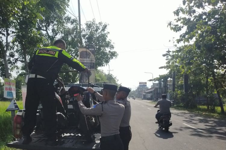 Polisi menaikkan dua sepeda motor yang terlibat kecelakaan di ruas jalan jurusan Geger ? Dagangan, Desa Dagangan, Kecamatan Dagangan, Kabupaten Madiun, Jawa Timur untuk diangkut ke atas mobil, Rabu (20/11/2024).