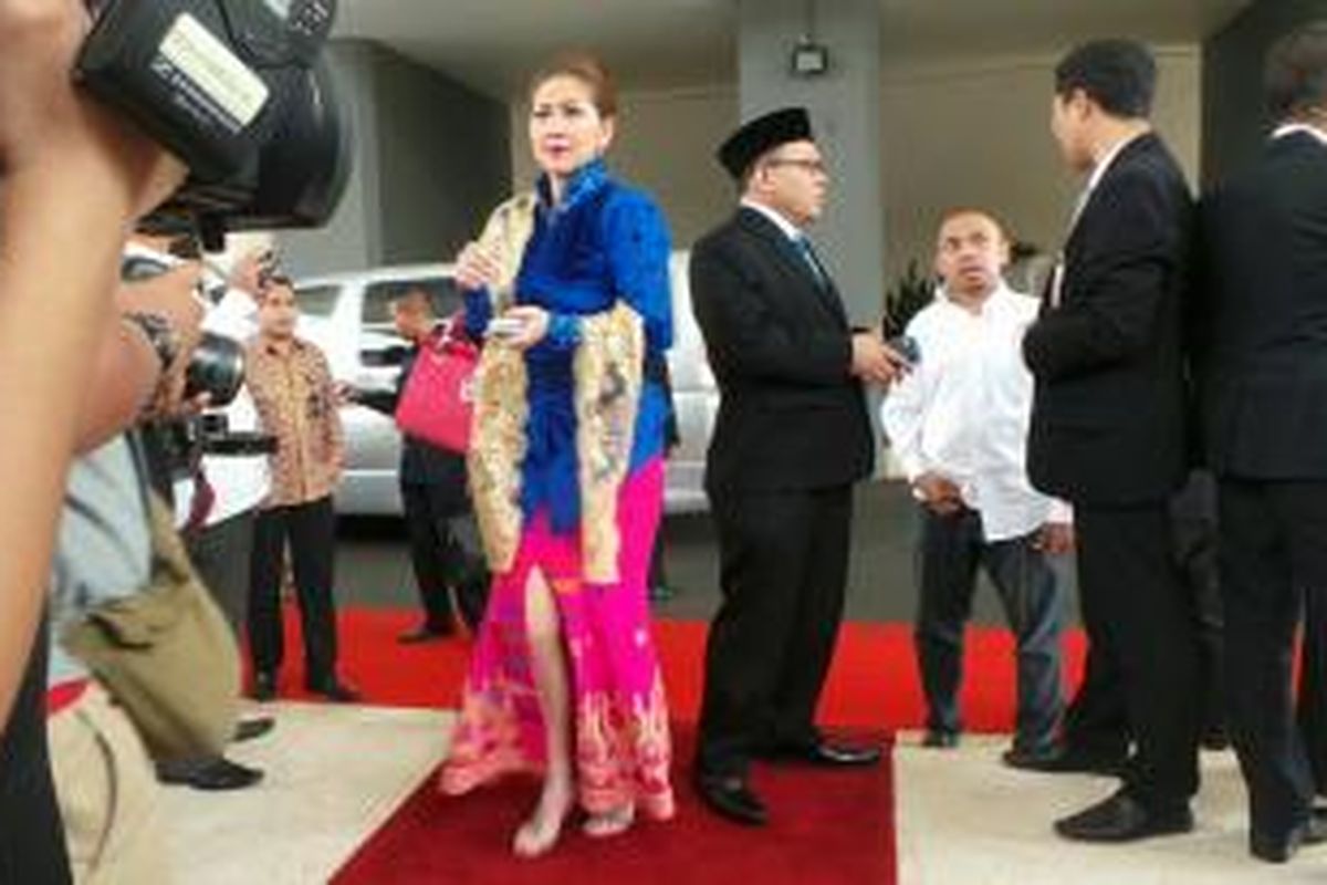 Venna Melinda mengenakan kebaya brokat warna biru cerah, kain songket Bali warna pink, dan selendang brokat warna keemasan ketika menghadiri pelantikan para anggota Dewan Perwakilan Rakyat Republik Indonesia (DPR RI) 2014-2019 di Gedung DPR RI, Senayan, Jakarta, Rabu (1/10/2014).