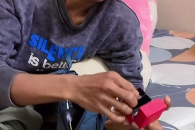 Moh Sirri menunjukkan anting yang akan dia hadiahkan kepada mendiang anaknya, Syifa (1). 