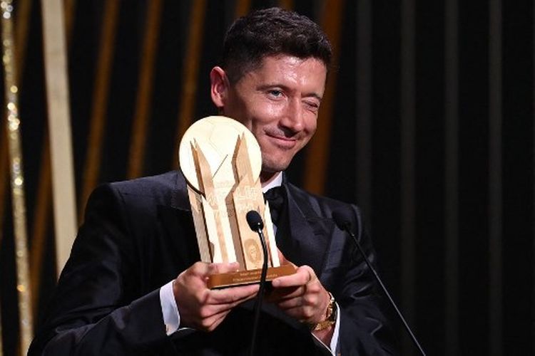 Striker Barcelona, Robert Lewandowski, mengangkat Gerd Mueller Trophy setelah dinobatkan sebagai penyerang terbaik pada malam penganugerahan Ballon d'Or 2022, Selasa (18/10/2022) dini hari WIB.