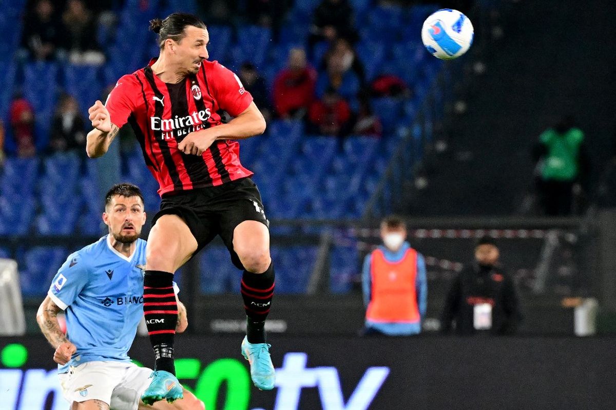 Penyerang AC Milan, Zlatan Ibrahimovic, menanduk bola di hadapan bek Lazio, Francesco Acerbi, dalam laga Liga Italia 2021-2022 antara Lazio vs AC Milan di Stadion Olimpico, 24 April 2022.