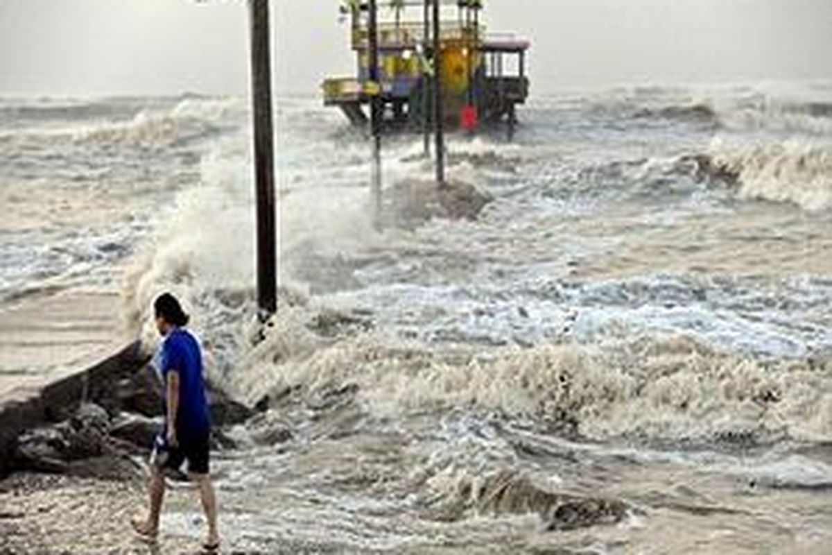 Seorang warga berjalan di tepi laut Galveston saat terjangan Ike menimbulkan gelombang laut tinggi