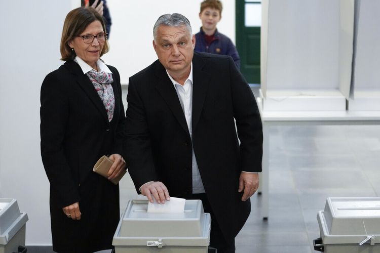 Perdana Menteri nasionalis Hongaria, Viktor Orban, tengah, dan istrinya Aniko Levai, kiri, memberikan suara mereka untuk pemilihan umum di Budapest, Hongaria, Minggu, 3 April 2022. 