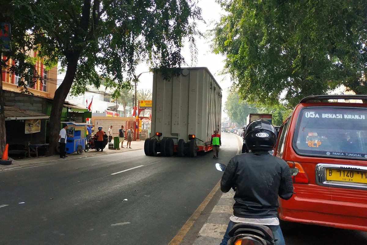 Satu unit kontainer bertonase besar terpaksa bergerak mundur karena tidak bisa melintasi ruas Jalan Jenderal Sudirman, Bekasi, dikarenakan adanya jembatan penyeberangan, Kamis (22/8/2019).