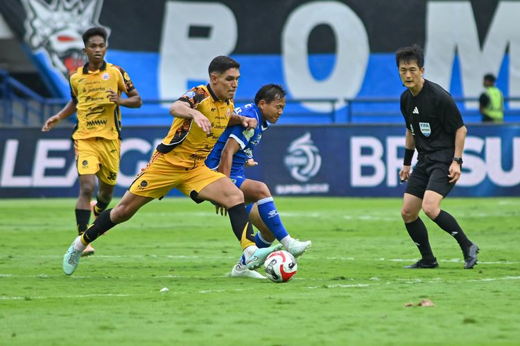 Gelandagn Persija Jakarta Van Basty Souza berduel dengan gelandang Persib Bandung Adam Alis pada laga pekan ke-17 Super League 2025-2026, Minggu (11/1/2025) di Stadion Gelora Bandung Lautan Api (GBLA). 