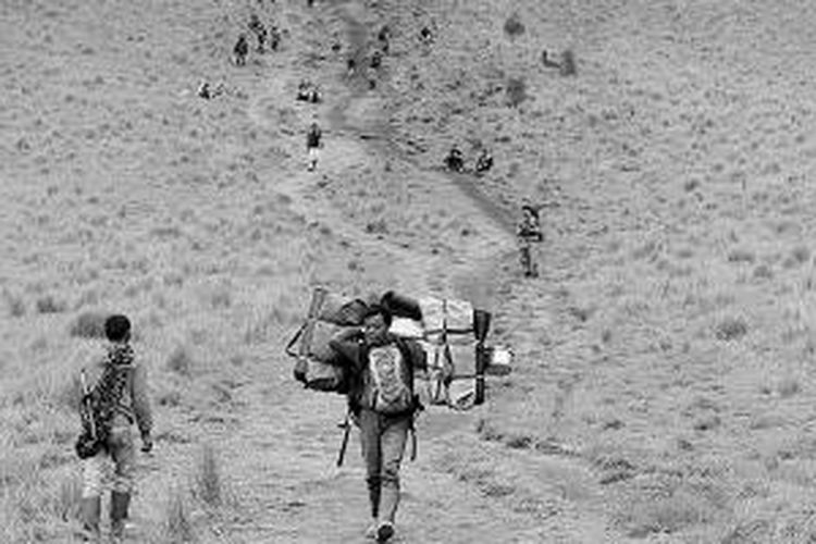 Porter berjalan menuruni 'Tanjakan Cinta' di kawasan Gunung Semeru, Jawa Timur, Selasa (31/12/2013). Para porter yang tinggal di sekitar Semeru turut kecipratan berkah dengan kedatangan ratusan pendaki yang merayakan pergantian tahun di gunung berketinggian 3.676 meter di atas permukaan laut tersebut. 