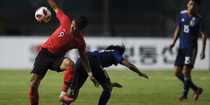 Pemain Korea Selatan, Hwang Hee-chan, memperebutkan bola dengan pemain Jepang, Taishi Matsumoto, pada laga final Asian Games 2018 di Stadion Pakansari, 1 September 2018. 