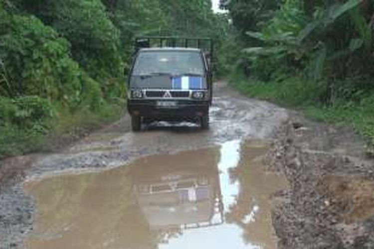 Sebuah kendaraan terlihat berhati-hati dan melambatkan laju kendaraanya saat melintas di jalan provinsi penghubung antara Kabupaten Ogan Ilir ke Kabupaten OKU yang kondisinya rusak parah